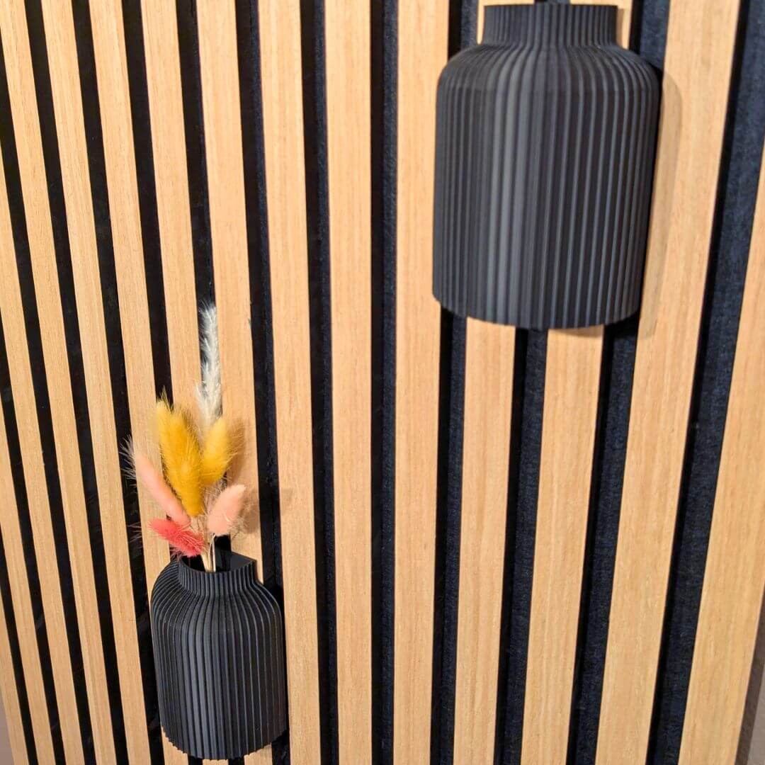 Zwei moderne 3D-Druck Vasen von Mondhäuschen auf einem Akustikpaneel aus Eiche, dekoriert mit Trockenblumen – stilvolle Wanddekoration für Wohnzimmer oder Büro.